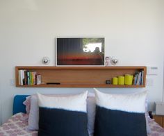 a bed with two pillows and a book shelf above it