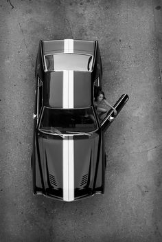 a black and white photo of a sports car with the hood down, taken from above