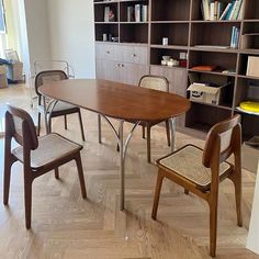 a dining room table and chairs with bookshelves in the background