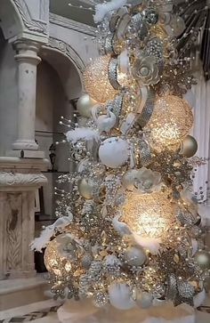 a white christmas tree with silver and gold ornaments