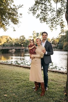 a man, woman and child are standing in front of a lake