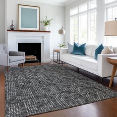 a living room filled with furniture and a fire place next to a white couch on top of a hard wood floor