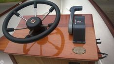 the steering wheel on a boat is next to an electronic device and remote control unit