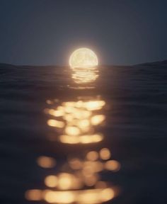 the full moon is reflected in the water as it rises above the ocean's surface