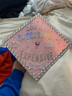 a pink graduation cap with words on it