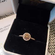 an engagement ring in a velvet box with the lid open to show it's diamond center