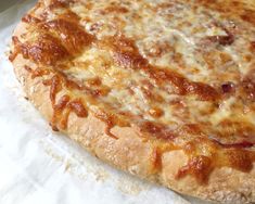 a cheese pizza sitting on top of a piece of paper