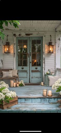 the front porch is decorated with white flowers and candles for an inviting touch to the home