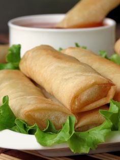 some food that is on a plate with lettuce and sauce in the background