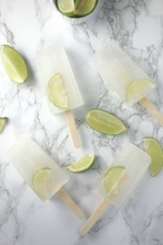 limeade popsicles on a marble counter with limes