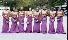 a group of women standing next to each other wearing purple dresses and holding bouquets