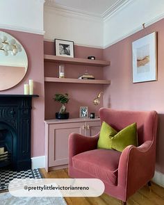 a pink chair sitting in front of a fire place next to a wall mounted mirror