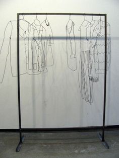 an art piece with clothes hanging on it