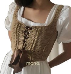 a woman wearing a brown crochet top with a bow on the front and shoulder