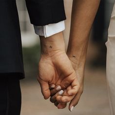 a couple holding hands while standing next to each other