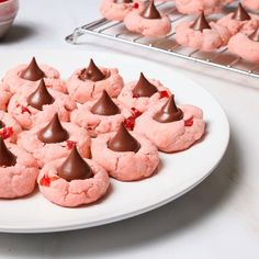 a white plate topped with pink cookies covered in chocolate