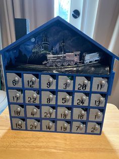 a house shaped like a calendar with a train on the front and numbers below it