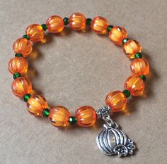 Pumpkin stretch beaded fashion charm bracelet This pumpkin charm bracelet is a super fun, bright piece to add to your fall jewelry collection! Wear it with other bracelets for a trendy stacked look. Wear anytime, anywhere!Handcrafted in the USA Featuring: orange pumpkin beads with tiny green glass beads to look like pumpkin stems — topped with a rustic pumpkin charm! Size: One size fits most Materials: acrylic beads, elastic cord, alloy Colors: Orange, green, silver *Actual color may appear diff Thanksgiving Bracelet Beaded, Trendy Beaded Jewelry Fall, Cheap Casual Halloween Bracelets, Cheap Orange Halloween Bracelets, Halloween Beaded Jewelry, Pumpkin Stems, Pumpkin Beads, Beaded Fashion, Autumn Bracelet