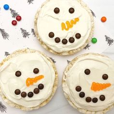 three decorated cookies with frosting and candy on them