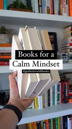 a person holding up a book in front of bookshelves with text reading books for a calm mindset