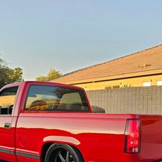 a red pick up truck parked in front of a house