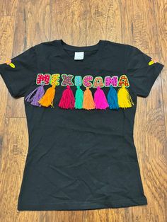 "Thanks for stopping by my shop ❣️Connecting Mexican Artisans and Handmade products with you❣️ Novelty t-shirt made in Mexico Perfect for any Mexican-style party, as it has a colorful design, 5 de mayo, \"Mexicana embroidered  mexican party theme Materials- cotton/Polyester   Hand embroidered  https://www.facebook.com/xolalbymw 🟪Beautiful mexicana t-shirt round neck ⚫️XS size ➡️width 15\"x Length 22\" 🟡Small ➡️ width 16\" x length 23\" ⚪️medium size➡️ with 21\" x length 27\" Please feel free to ask me any question" Black Embroidered T-shirt For Summer, Black Bohemian T-shirt For Festival, Multicolor Crew Neck Shirt For Cinco De Mayo, Black Bohemian T-shirt With Letter Print, Multicolor Letter Print Tops For Cinco De Mayo, Black Letter Print Tops For Festival, Black Screen Print Tops For Festival, Black Crew Neck Top With Custom Embroidery, Black Cotton Festival Tops