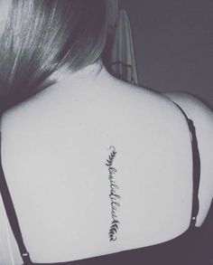 the back of a woman's shoulder with a tattoo on it