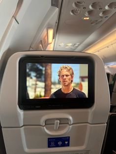 the screen on the back of an airplane shows a man's face