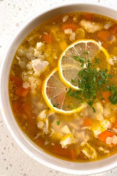 a white bowl filled with soup and lemon slices