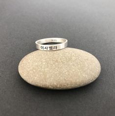 This listing is for a personalized burnished matte sterling silver engraved Korean Name ring.The sample ring is engraved with a name Isabella in Korean in the font #1. Please check the font options in the pictures. Outside or/and inside of the ring can be engraved. The sample ring is about 3 mm wide. All orders come gift-wrapped.Avoid dust, moisture and direct light to ensure the jewelry does not tarnish and discolor.<< How to order >>Please choose engravings sides and a ring size fr Name Isabella, Korean Characters, Name Ring, Korean Jewelry, Name Rings, Korean Name, Sterling Silver Rings Bands, Numbers Font, Traditional Fabric