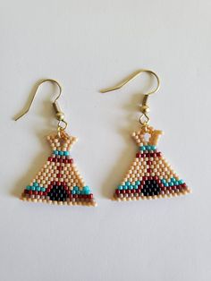 a pair of beaded earrings on a white surface