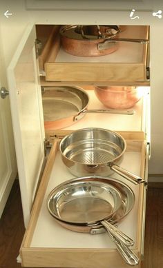 an open drawer with pots and pans in it