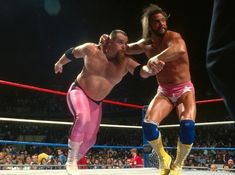 two men in wrestling gear standing next to each other