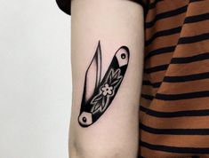 a tattoo on the arm of a woman with a knife and flower in its blade