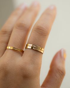 a woman's hand with a gold ring on her left hand and the word mama written in cursive writing on it