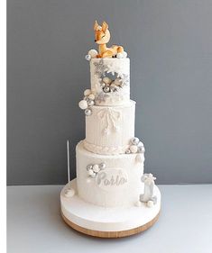 a three tiered wedding cake with an animal on top