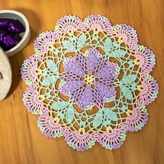 a crocheted doily next to a pair of shoes on a wooden table