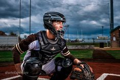 a baseball player kneeling on the field with his catchers mitt in front of him