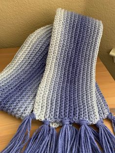 a blue and white scarf sitting on top of a wooden table