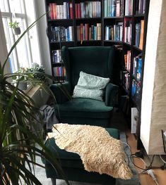 a chair and ottoman in front of a bookcase with books on the shelves behind it