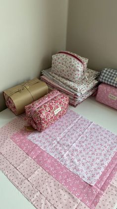 several pieces of pink and white fabric laid out on top of each other in a room