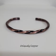 a close up of a metal object on a white surface with the words unique copper