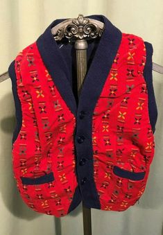 "This is a sweet vintage, toddler's sweater vest from the 50s. Label reads, Wee Men, Styled by Kaynee\". Tagged a size 3. Chest measures 21\", please see measurements below. Made of blue knit with a red print corduroy front. Buttons down the front & has 2 small pockets. The vest is in good condition. No soil, stains. No damage. Too cute! Measurements were taken with the garment laying flat. Please measure your child or a similar garment that fits your child well!! Vintage sizes run smaller t Vintage Cotton Sweater Vest For Winter, Vintage Red Sweater Vest For Fall, Red Vintage Sweater Vest For Fall, Red Cotton Retro Vest, Red Retro Cotton Vest, Retro Red Cotton Vest, Retro Winter Sweater Vest, Red Retro Winter Vest, Retro Red Winter Vest