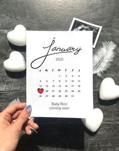 someone holding up a calendar with hearts on it