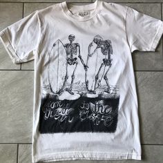 Organic Cotton Never Worn Surfing Skeletons T-Shirt Small By La Based Clean Aesthetics . Made In The Usa. Off White Color. Never Worn, Tags Removed. Summer Crew Neck Top With Back Print, White Vsco T-shirt With Text Print, Summer Band Merch T-shirt With Back Print, Summer Streetwear Tops With Back Print, Grunge Cotton Tops With Front Print, Spring Vsco Streetwear Tops, Vsco Style Crew Neck T-shirt For Streetwear, Summer Cotton Tops With Back Print, Fitted Crew Neck Top With Back Print