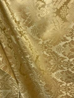 a close up view of a gold and white wallpaper with floral designs on it