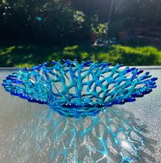 a blue glass bowl sitting on top of a table