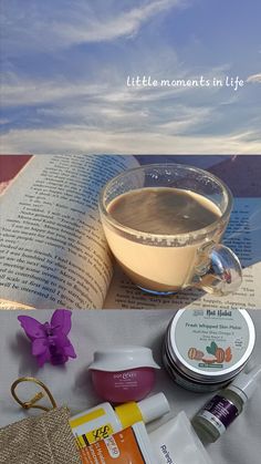 a cup of coffee and some other items on a table next to an open book