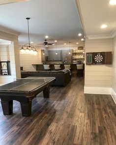 a living room filled with furniture and a pool table