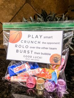 a bag filled with candy sitting on top of a counter next to a sign that says play smart rolo over the other team